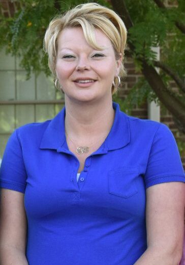 A woman wearing blue shirt and smiling